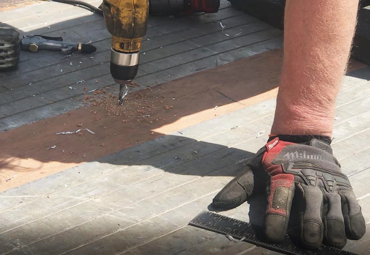 Predrilling a 7/32 inch hole through Apitong trailer decking into a steel cross member