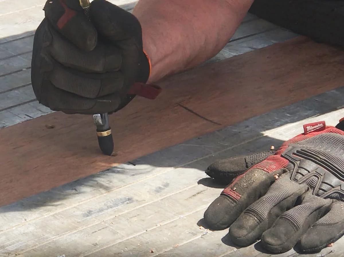 Cleaning chips out of a predrilled hole with compressed air before driving a screw